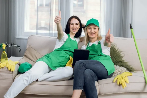 smiling-cleaners-showing-thumbs-up-and-using-tablet smiling-cleaners-showing-thumbs-up-and-using-tablet